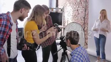 摄影工作室，摄影师公司在专业工作室培训期间讨论安装单反相机